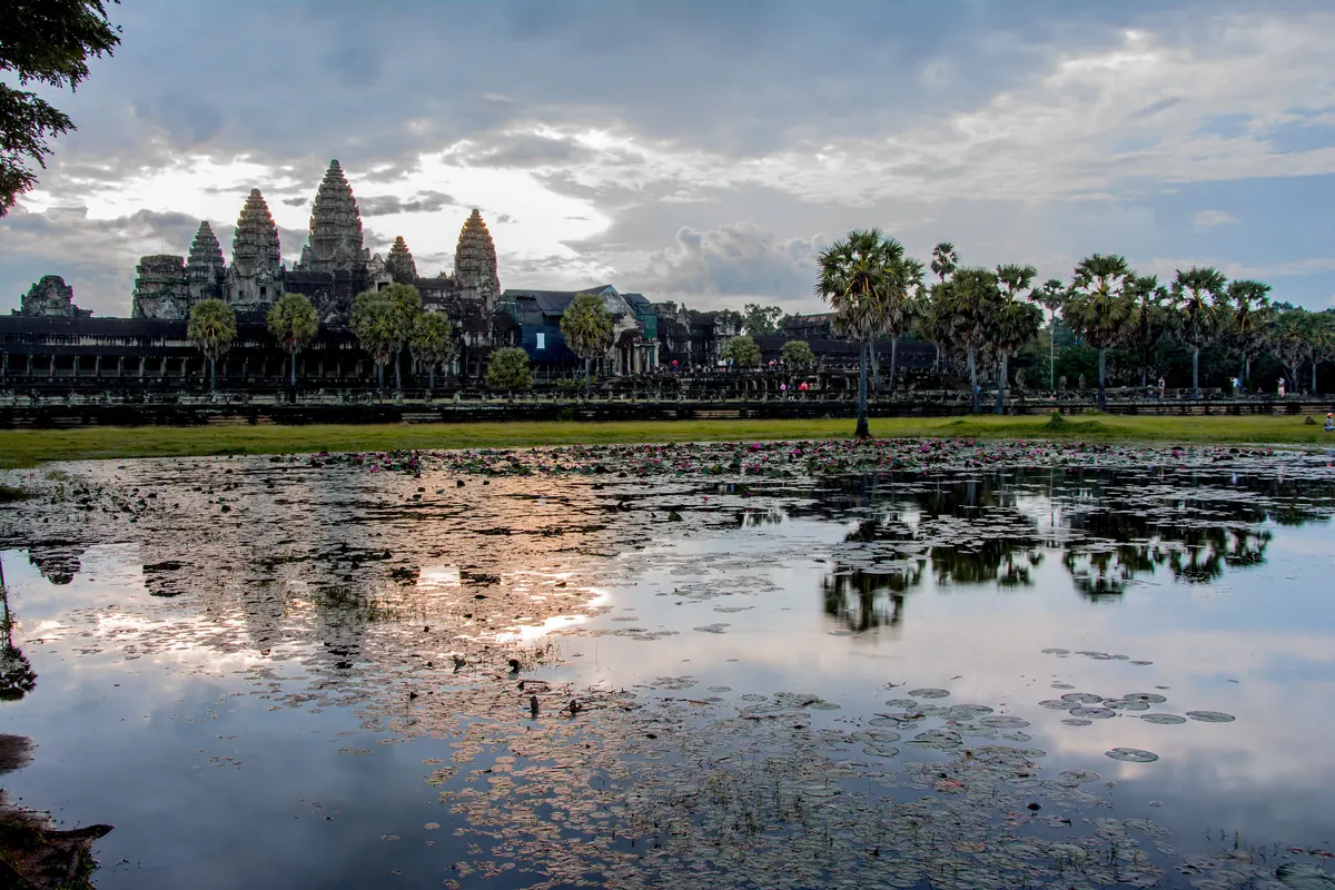 The towers of Angkor Wat reflected in the temple moat at sunrise