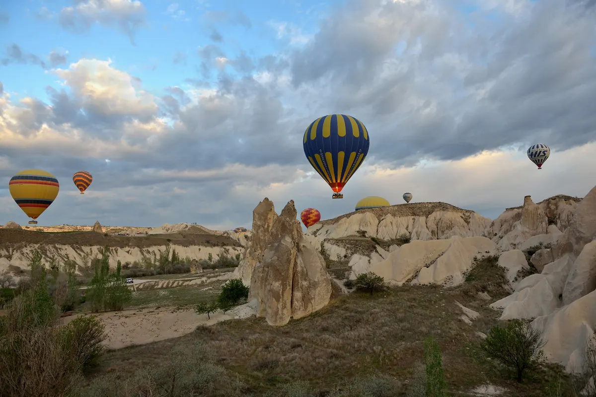 Hot air balloons rising over the rock valleys of Cappadocia at sunrise