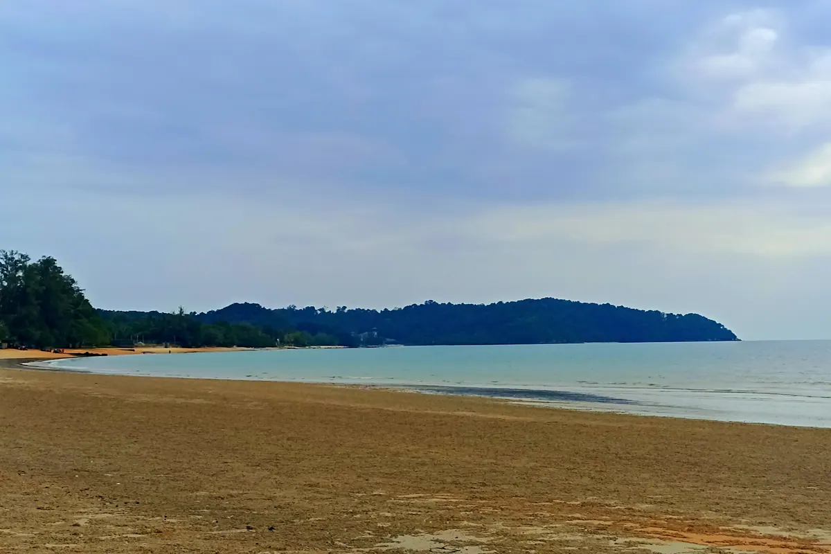 Sandy beach and a forested headland on the coast at Port Dickson